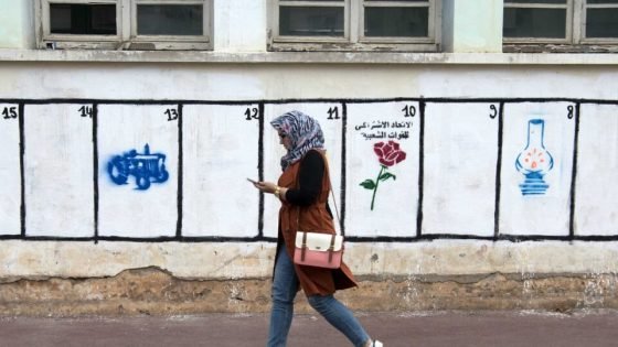 A Moroccan woman walks past a wall on which are painted the symbols of the political parties running for the parliamentary elections in the Moroccan capital Rabat on October 7, 2016. From L to R : the tractor stands for the Party on Authenticity and Modernity, the rose stands for the Socialist Union of Popular Forces (USFP)and the lamp stands for the Party of Justice and Development. - Moroccans voted to elect a new parliament, five years after an Islamist-led government took office following Arab Spring-inspired protests that toppled regimes across the region. To make life easier for the illiterate, who make up a third of Morocco's population, the 30 parties in contention were marked on ballot papers with symbols such as a tractor or camel. (Photo by FADEL SENNA / AFP)