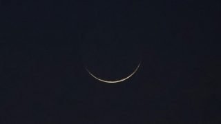 A crescent moon is seen, as Muslims attend an evening prayer session called 'Tarawih' to mark the holy fasting month of Ramadan in Karachi, Pakistan March 11, 2024. REUTERS/Akhtar Soomro